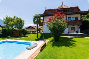 a house with a swimming pool in front of a yard at Ferienwohnungen Haus Christine in Rifiano