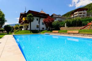 a swimming pool in front of a house at Ferienwohnungen Haus Christine in Rifiano