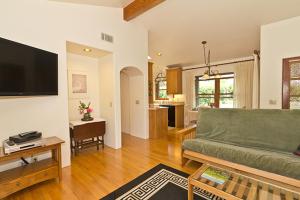 een woonkamer met een groene bank en een keuken bij Custom Mediterranean-Style Santa Barbara Apartment in Carpinteria