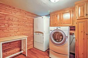 a laundry room with a refrigerator and a washer at Cozy A-Frame Center Barnstead House on Locke Lake! in Barnstead