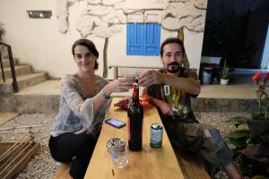 un hombre y una mujer sentados en una mesa con una botella de vino en Kontum Home Sweet Homestay, en Kon Tum