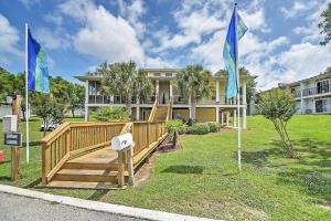 a house with two flags in front of it at Ocean Springs Condo in Waterfront Resort! in Ocean Springs