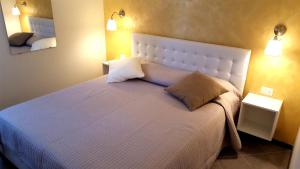 a bedroom with a large white bed with two pillows at Premium Apartments Peschiera in Peschiera del Garda