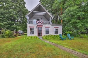 uma casa branca com duas cadeiras azuis no quintal em Northville Lakefront Escape with Deck Walk to Lake em Benson