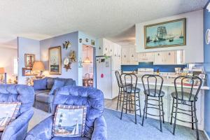 a living room with blue furniture and a kitchen at Wine Country Oasis with Waterfront Terrace and Dock! in Clearlake Oaks