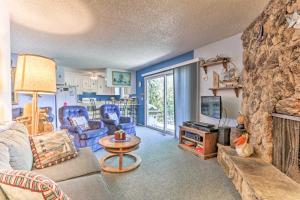 a living room with a couch and a stone fireplace at Wine Country Oasis with Waterfront Terrace and Dock! in Clearlake Oaks