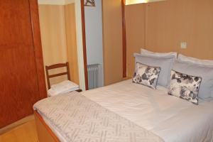una camera da letto con letto, cuscini e sedia di Residencial Paranhos a Porto