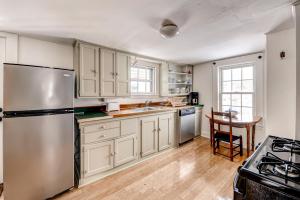 uma cozinha com armários brancos e um frigorífico de aço inoxidável em Ipswich Cottage with Beautiful Views, 5 Mins to Beach em Ipswich