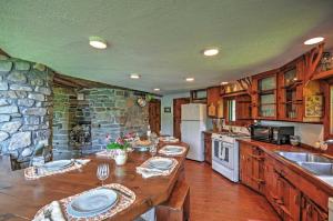 a kitchen with a table and a stone wall at Dragonwood Castle on Waterfront with Stunning View in Prospect Harbor