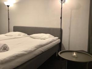 a bed with a white blanket and a lamp at Acco Hostel in Stockholm