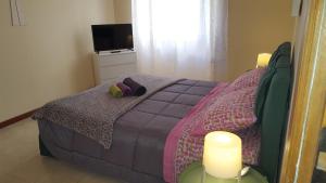 1 dormitorio con 1 cama, 2 velas y TV en Uso Turistico vicino San Giovanni en Roma