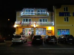 un edificio con coches estacionados en un estacionamiento por la noche en Vila Queen, en Arad