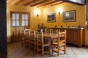 a dining room with a wooden table and chairs at Casa Rural Roblejimeno in Cubillo del César