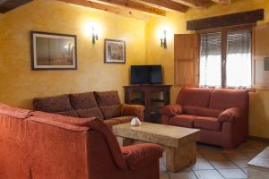 sala de estar con 2 sofás y TV en Casa Rural Roblejimeno, en Cubillo del César