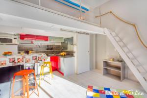 a kitchen with red and white cabinets and a staircase at Cocooning 1 bedroom with mezzanine - Dodo et Tartine in Toulon