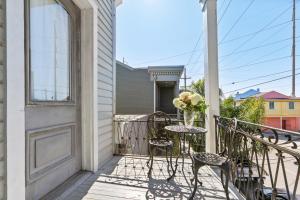 un balcón con una mesa con sillas y un jarrón de flores en Montgomery House en Nueva Orleans