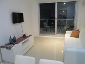 sala de estar con sofá blanco y TV en Ayres del Puerto, en Punta del Este