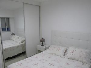 a white bedroom with a mirror and a bed at Ayres del Puerto in Punta del Este +12 photos