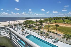 a balcony with a swimming pool and a beach at Beachside Biloxi Club Condo Balcony with Ocean View in Biloxi