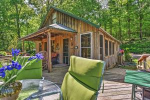 een houten hut met een tafel en stoelen op een terras bij Private Getaway on 270 Acres with Lake Swim and Canoe in Marble Hill