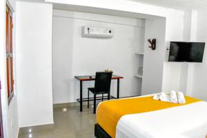 Una habitación de hotel con dos camas y un escritorio. en Hotel Casa Tere, en Cartagena de Indias
