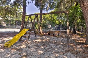 a playground with a yellow slide in a park at Walk to Beach Resort-Style Hilton Head Condo! in Hilton Head Island