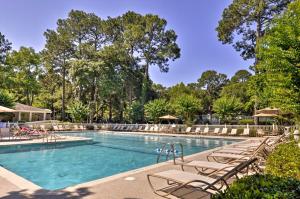 a large swimming pool with chairs and trees at Walk to Beach Resort-Style Hilton Head Condo! in Hilton Head Island