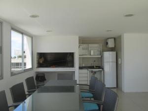a kitchen with a table and chairs and a refrigerator at Ayres del Puerto in Punta del Este
