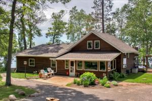 una casa de madera con porche y árboles en Spacious Brainerd Home by Dwtn - Summer Paradise!, en Brainerd