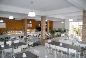 a restaurant with white tables and white chairs at Portal do Sol in Itaberaba