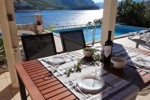 una mesa con una botella de vino y copas en el balcón en Villa Silencia en Trstenik