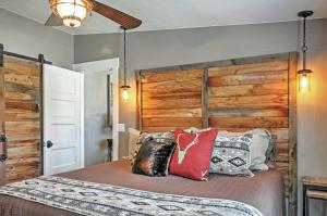 een slaapkamer met een bed met een houten hoofdeinde en kussens bij Rustic Chic Home 10 Mi to Otter Creek State Park! in Circleville