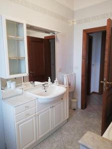 La salle de bains blanche est pourvue d'un lavabo et d'un miroir. dans l'établissement Casa La Fonte, à Altopascio