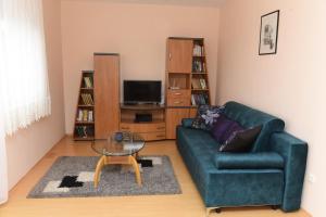 ein Wohnzimmer mit einem grünen Sofa und einem Couchtisch in der Unterkunft Bingo Apartments in Banja Luka