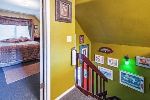 スワードにあるSecluded Seward Home Patio, 2 Mi to Kenai Fjords!の黄色の壁のベッドルーム1室、ベッド1台、階段