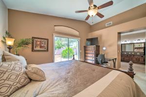 een slaapkamer met een bed en een plafondventilator bij Bright Chandler Home with Hot Tub Golf, Hike and Shop in Chandler