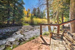 斯诺马斯Charming Creekside Snowmass Studio 15 Mi to Aspen的木凳,坐在河边