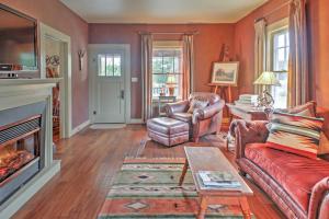 een woonkamer met rode meubels en een open haard bij August Schmidt Fredericksburg Cottage with Hot Tub in Fredericksburg