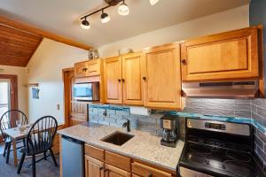 een keuken met houten kasten en een fornuis met oven bij Heart of Superior Lake Cabin 15 Mi to Lutsen Mtn! in Schroeder