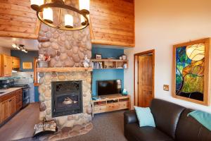 a living room with a stone fireplace and a couch at Heart of Superior Lake Cabin 15 Mi to Lutsen Mtn! in Schroeder