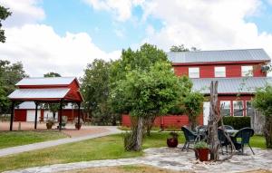 a red barn with a table and chairs in front of it at Ark Bunkhouse Fredericksburg Hideaway with Hot Tub in Fredericksburg