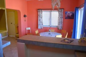 uma cozinha com paredes cor de laranja e uma mesa num quarto em Kasa Mona em Calheta Do Maio