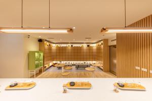 une grande salle avec une salle d'attente dotée de tables et de chaises dans l'établissement CHO Stay Capsule Hotel-Taoyuan Airport T2, à Dayuan