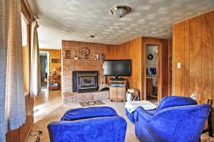 Sala de estar con 2 sillas azules y TV en South Fork Log Cabin with Beautiful Mountain Views!, en South Fork