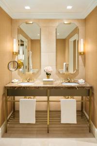 a bathroom with two sinks and a large mirror at Rosewood Mansion on Turtle Creek in Dallas