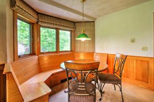 uma sala de jantar com mesa, cadeiras e janelas em Scenic Bartlett Home with Deck - 1 Mi to Storyland! em Bartlett
