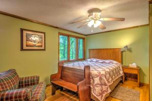 um quarto com uma cama e uma cadeira e uma ventoinha de tecto em Waterfront New Concord Paradise on Kentucky Lake! em Faxon