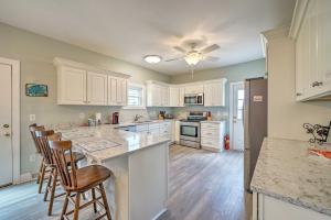 a kitchen with white cabinets and a large island with bar stools at Updated Family Getaway Walk to Sea Haven Beach! in North Topsail Beach