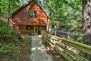 een blokhut in het bos met een hek bij Gatlinburg Cabin with Hot Tub 5 Mi to Downtown in Gatlinburg