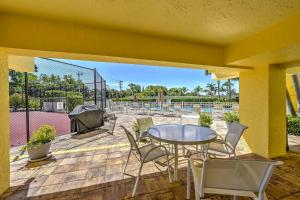 a patio with a table and chairs and a grill at Marco Island Condo with Patio Steps to Beach Access in Marco Island